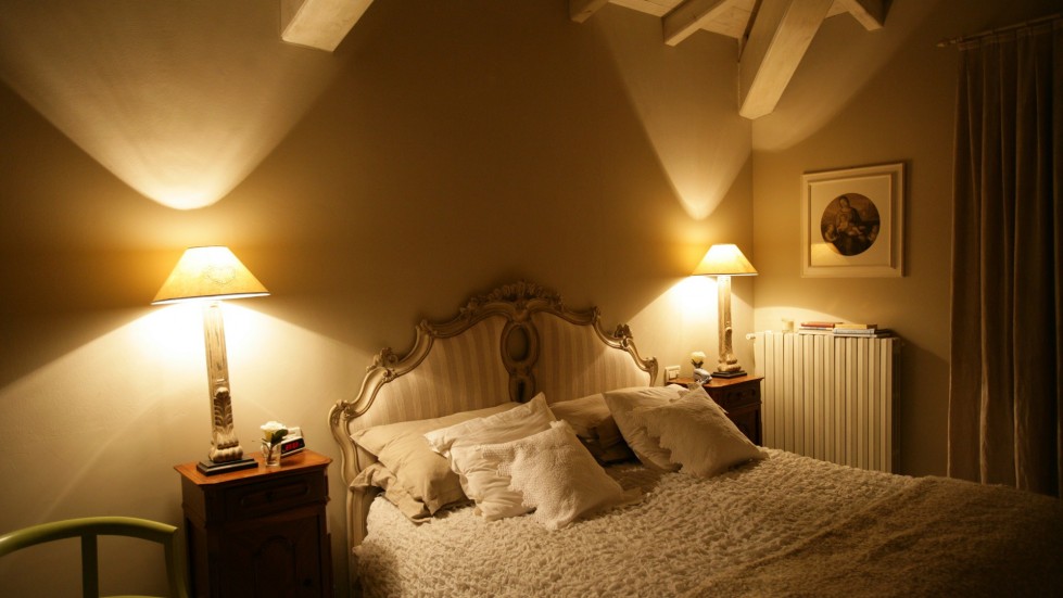 Soft lamplight in a bedroom corner with textiles suggesting rest after a quiet meal, no promotional text in the image